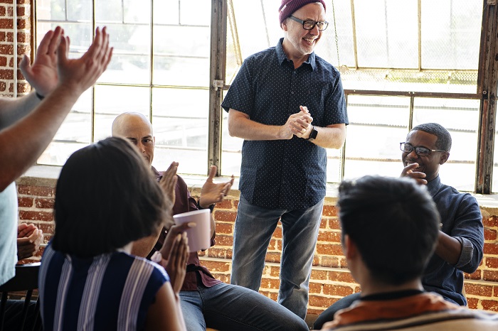 Man-standing-smiling-in-group-therapy-session