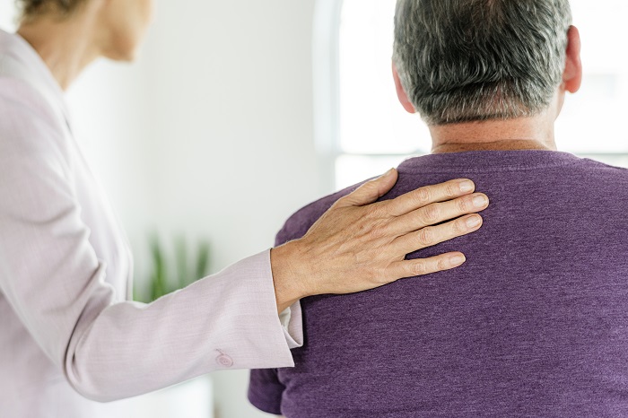 Man-with-therapists-hand-on-his-back